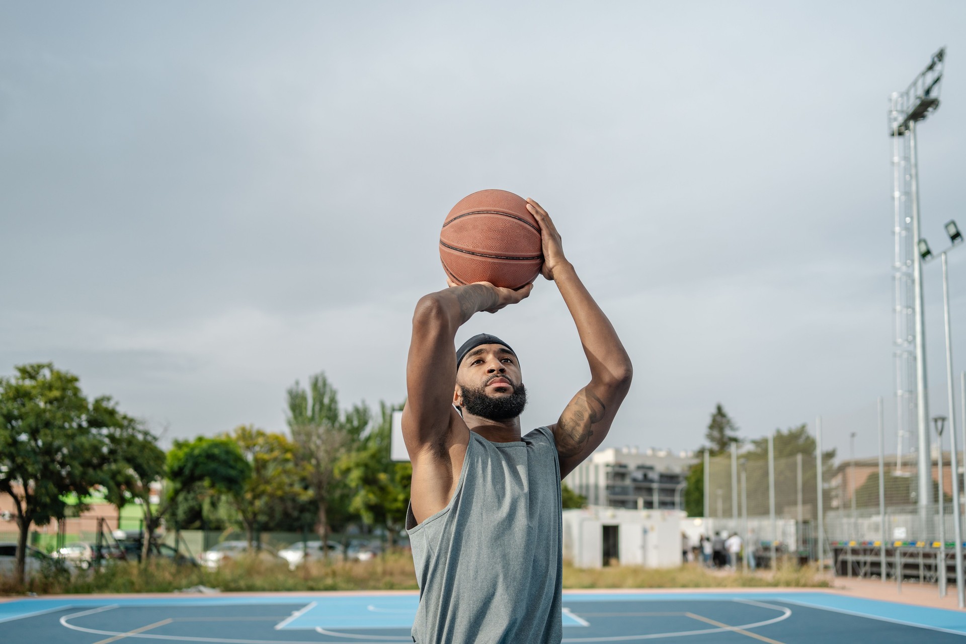 Young basketball player shooting a ball on an outdoor court